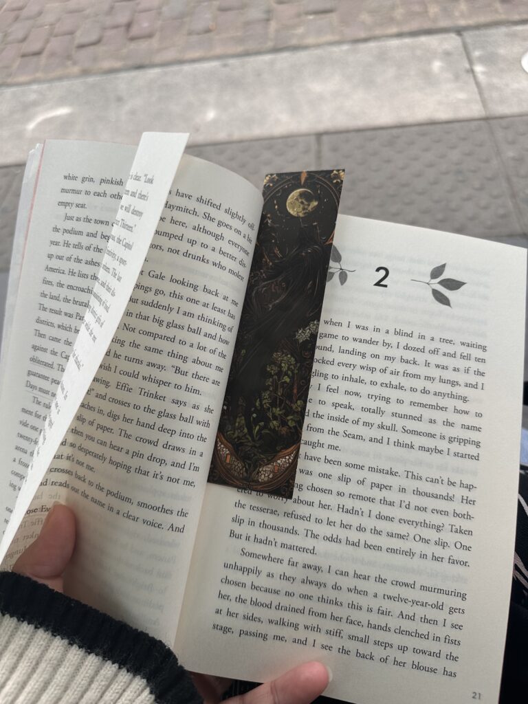 A picture of The Hunger Games open to chapter 2 with a bookmark in the middle.